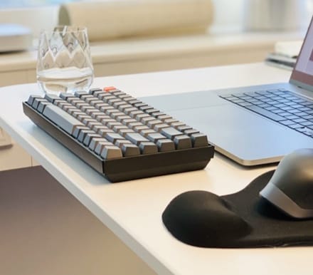 keyboard on desktop with glass and laptop